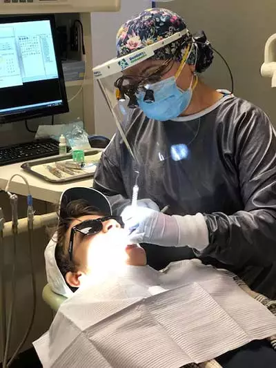 dental hygienist cleaning a patient's teeth